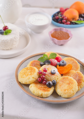 Cheesecakes with fresh berries on a table with a white tablecloth