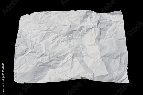 a sheet of white crumpled paper is isolated on a black background