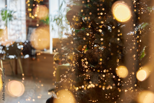 Christmas tree decorated with toys and garland on background of living room. Christmas and New Year background