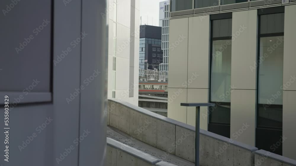 Moving train seen in a gap between buildings. Modern architecture. Moving train seen in a gap between buildings. Modern architecture.