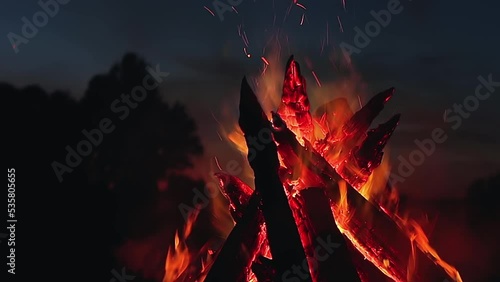 Big Burning Campfire at Summer Night against the Blue Sky. Wood on Fire. Flying Sparks. Travel and Tourism Concept. Giant Flaming Bonfire - Static Shot, Slow Motion