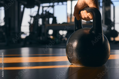 Close up image of fitness man with kettlebell in gym © USM Photography