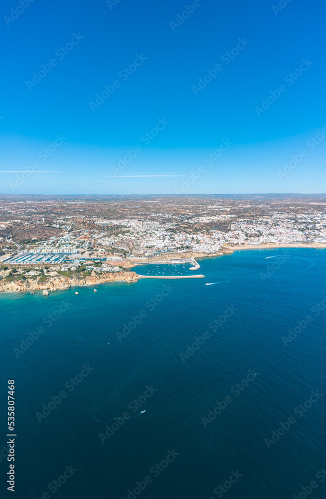 Vertical photography of Albufeira city. Perspective from above. Situated in South of Portugal is a famous travel destination. Beautiful Portuguese landscape with high rocky shore and luxury houses.