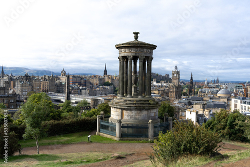 Calton hill with neoclassical monuments and striking view of the urban skyline