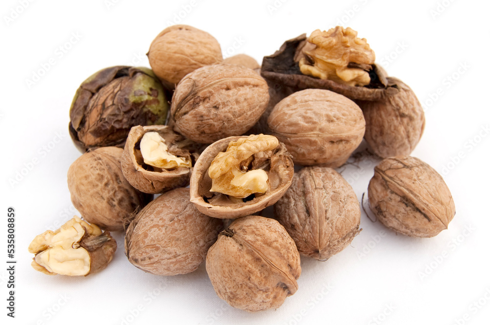 Heap of walnuts and a cracked walnut isolated on the white background Heap of walnuts and a cracked walnut isolated on the white background