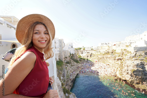 Portrait of tourist girl looking at camera from terrace in Polignano a mare, Apulia, Italy. Wide angle. photo