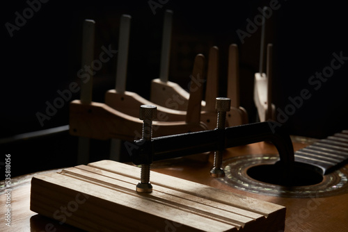 Foto Old guitar restoration with wooden clamps
