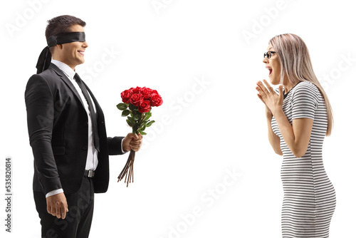 Photos Man with blindfold giving a bunch of red roses to an excited young woman