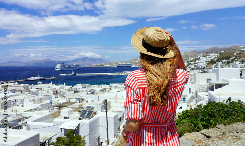 Panoramic banner view of tourist woman sees a cruise ship coming in Mykonos Island, Greece, Europe