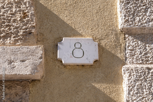 Number eight door number on plaster and brickwork