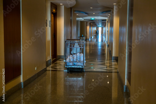 Housekeeping cart loaded with used towels. Hotel room maid trolley with towels. Hotel housekeeping maid laundry trolley with white used towel 