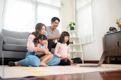 Asian family with children using laptop computer at home