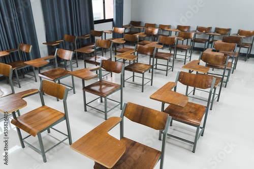 School classroom with many wooden chairs well-arranged in rows with no student