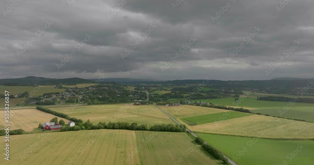Peaceful farmlands, dark clouds loom overhead. Lush fields, aerial drone. Peaceful farmlands, dark clouds loom overhead. Lush fields, aerial drone.