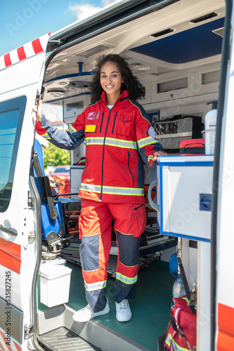 Joyous paramedic posing for the camera in the ambulance car