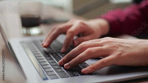 Close up of freelancer's developer hands typing program code on laptop keyboard in coworking. Businessman at work in working in office. Copywriter writing text on computer keyboard in coffeeshop.