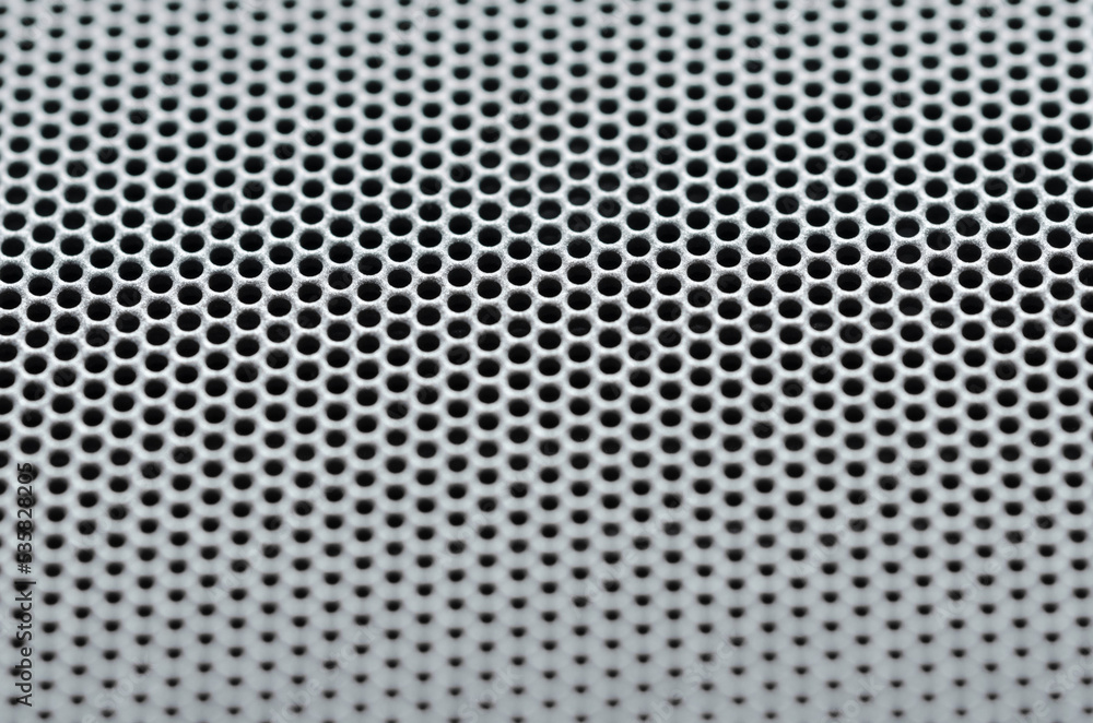 Macro of abstract metallic mesh surface with holes, dots or geometric patterns with shallow depth of field Macro of abstract metallic mesh surface with holes, dots or geometric patterns with shallow depth of field