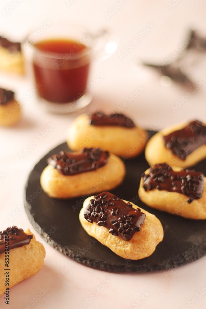 Traditional French dessert - eclairs with a cup of coffee Traditional French dessert - eclairs with a cup of coffee