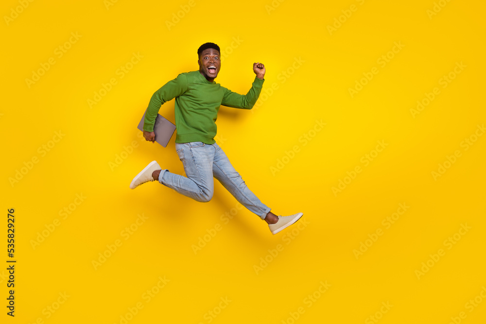 Full length body size view of handsome trendy guy it expert jumping running isolated over vivid yellow color background