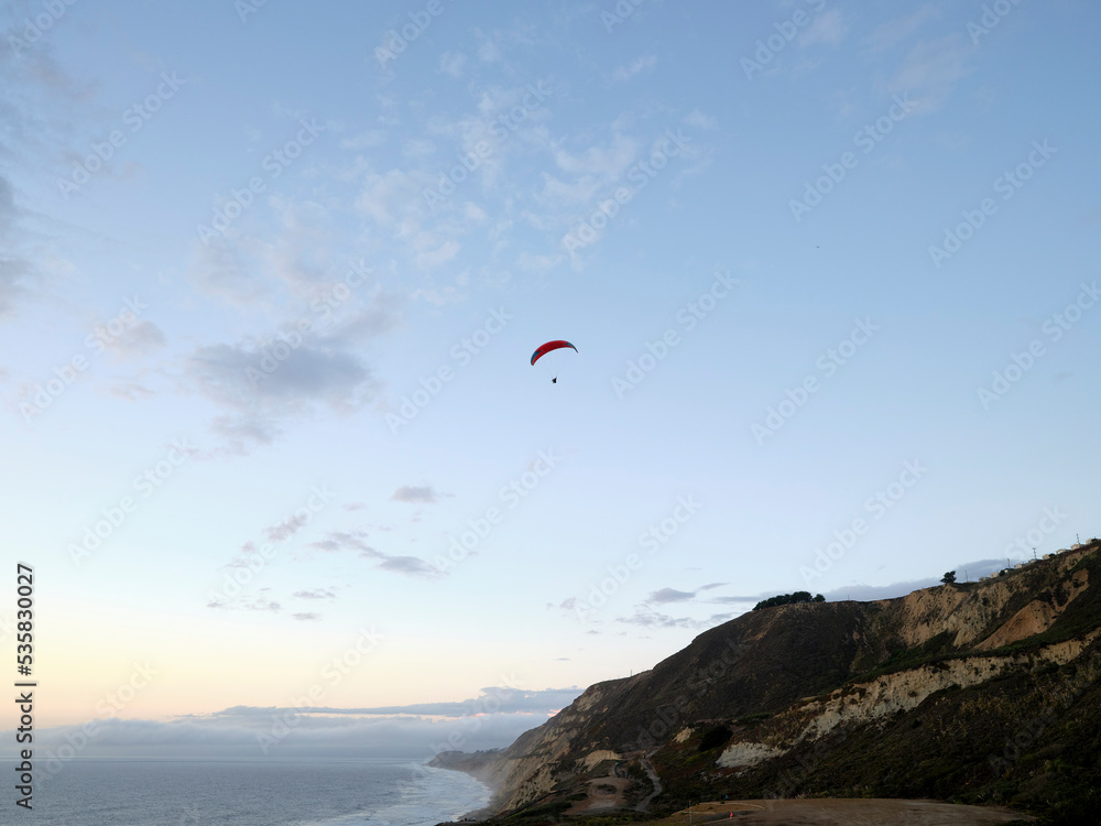 Parasailing over Pacific Ocean near coastal cliffs