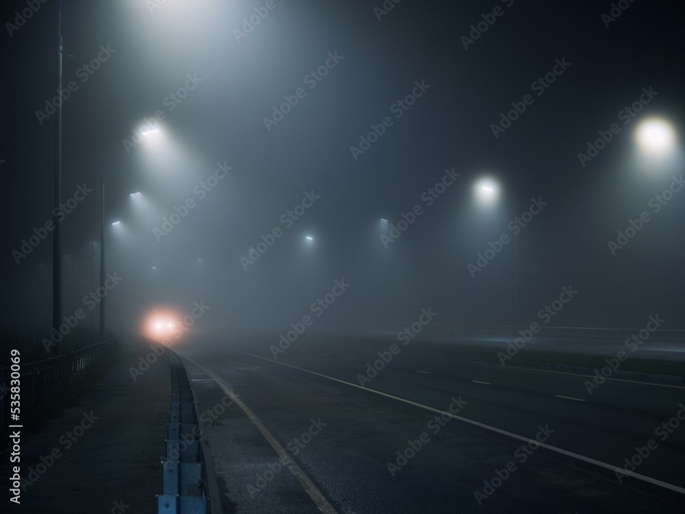 foggy road. night highway illuminated by lanterns foggy road. night highway illuminated by lanterns