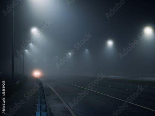 foggy road. night highway illuminated by lanterns