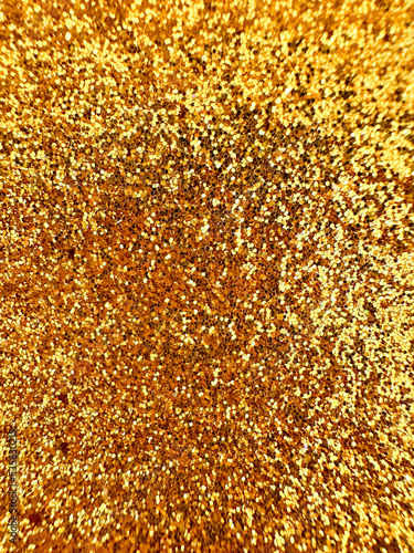 The fine texture of the gold glittering grainy surface