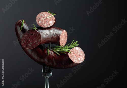 Spanish black pudding or blood sausage with rosemary on a fork.