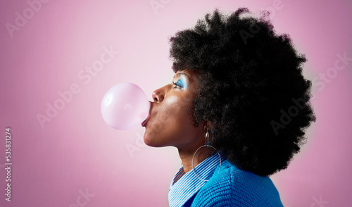 Bubble gum, afro hair and black woman on pink studio background with fashion, cool or Jamaican trend hairstyle. Profile, head or beauty model with bubblegum, makeup cosmetics and bold or fun attitude