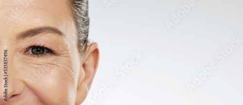 Fotografie Half face portrait, skincare and mature woman with beauty treatment standing in studio with mockup space