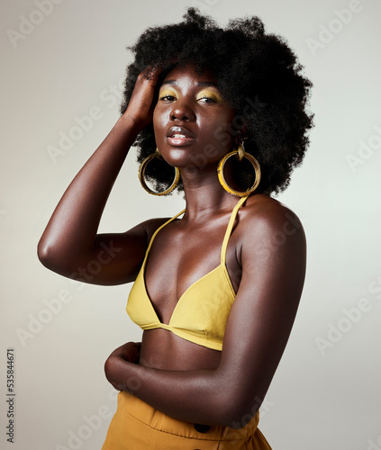 Black woman, beauty and fashion, makeup or hair care and gold jewelry on gray studio background. Portrait, hand in afro hair and skincare cosmetics model from Jamaica posing for female empowerment.