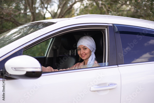 Cute muslim woman is sitting in the modern car.