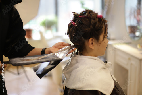 女性の髪のカラーリングをする男性美容師 © yamasan