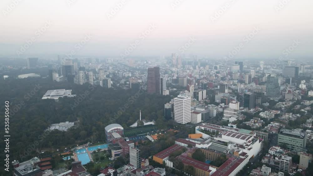 aerial drone dolly shot over mexico city with view of skyscrapers and a forest on a cloudy day aerial drone dolly shot over mexico city with view of skyscrapers and a forest on a cloudy day