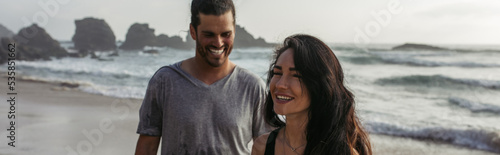 happy woman smiling near cheerful boyfriend on beach in portugal, banner.