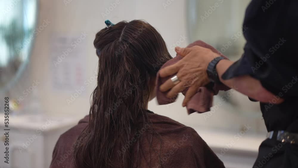 女性の髪を結ぶ男性美容師 女性の髪を結ぶ男性美容師