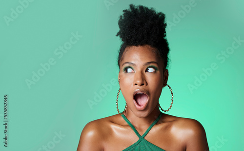 Surprise, trendy black woman and green studio background portrait with wow secret and style. Fashion and african american female makeup girl with deal, discount and gossip smile with mockup space photo