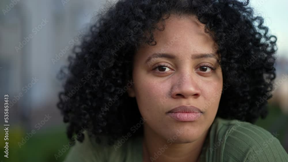 Portrait face of a young black woman looking at camera. A hispanic South American Brazilian adult girl with curly hair with natural expression Portrait face of a young black woman looking at camera. A hispanic South American Brazilian adult girl with curly hair with natural expression