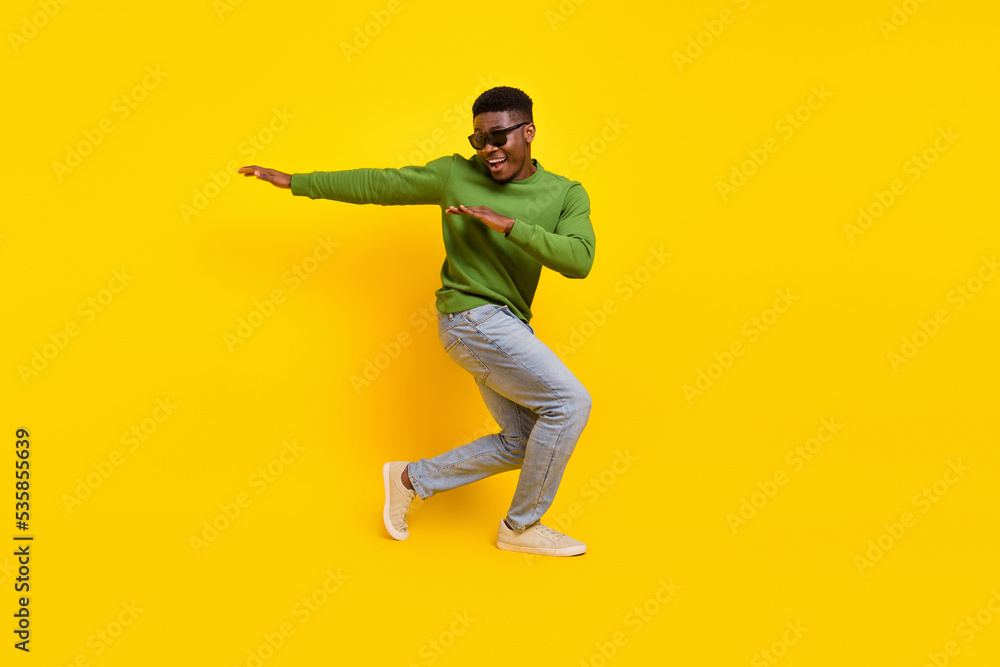 Full length body size view of attractive cheery guy dancing fooling having fun isolated on bright yellow color background