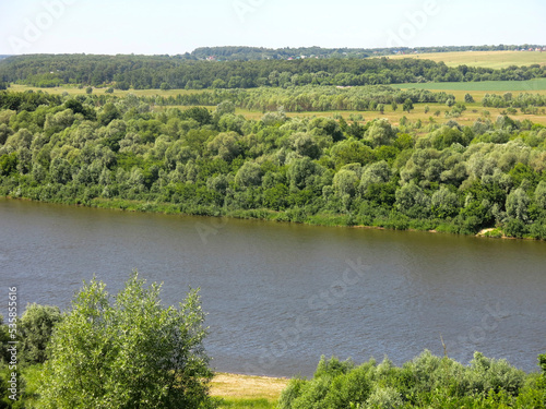 summer panorama of the Oka River with hills, fields and trees along the banks