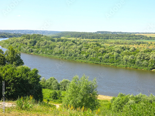 summer panorama of the Oka River with hills  fields and trees along the banks