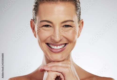 Skincare, anti aging and beautiful mature woman with a smile on her face on white background. Beauty, botox and collagen, a middle aged lady from USA with health, wellness and wrinkles on clean skin photo