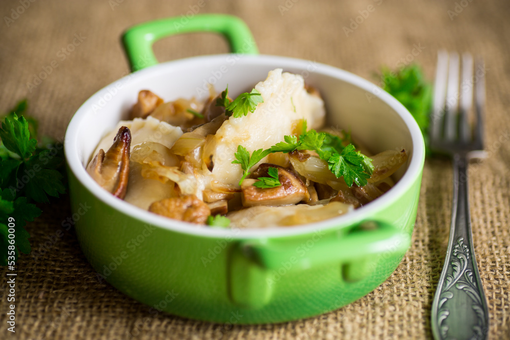 Potato dumplings with onion and mushrooms in a plate.