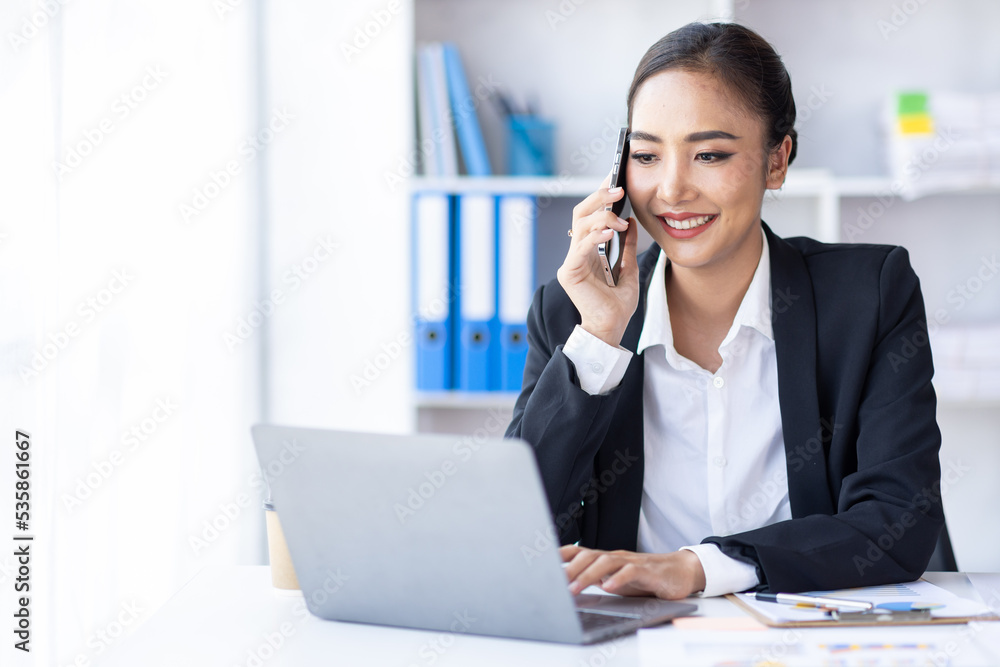 Beautiful Young business Asian Woman Talking on Smartphone in workplace Beautiful Young business Asian Woman Talking on Smartphone in workplace