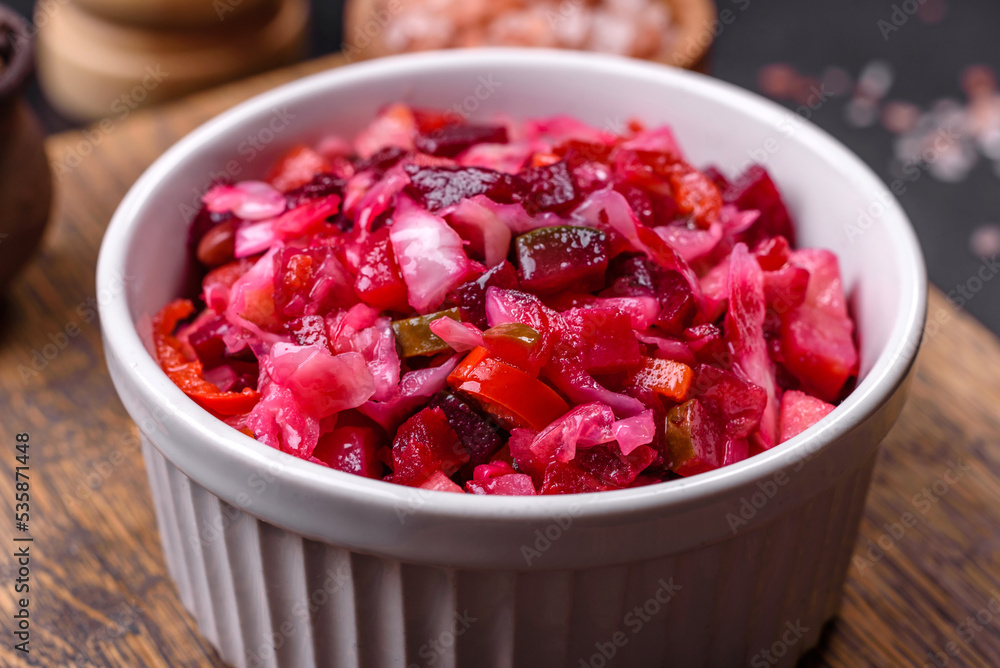 Traditional ukrainian beetroot salad vinaigrette on a white plate on a black concrete or slate background Traditional ukrainian beetroot salad vinaigrette on a white plate on a black concrete or slate background