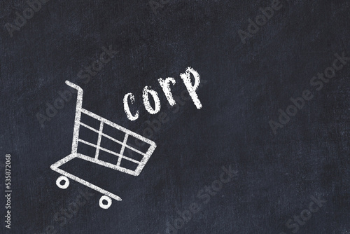 Chalk drawing of shopping cart and word corp on black chalboard. Concept of globalization and mass consuming