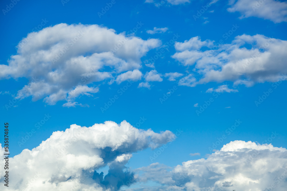 Fototapeta premium Sky background - white clouds on a bright blue sky gather into puffy clouds.