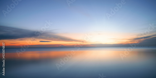 Foto Calm colored sea and sky at sunset
