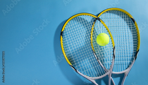 Tennis ball and rackets on the blue background.