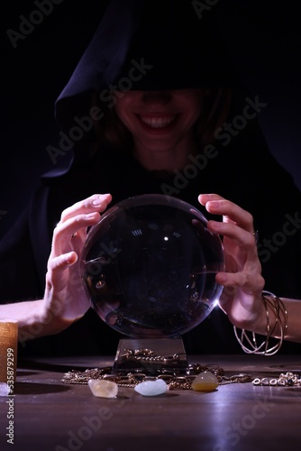 Canvas Print Soothsayer using crystal ball to predict future at table in darkness